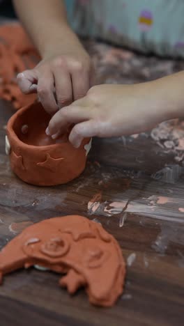 child creating pottery