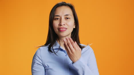 Joyful-trendy-filipino-adult-blowing-air-kisses-in-studio