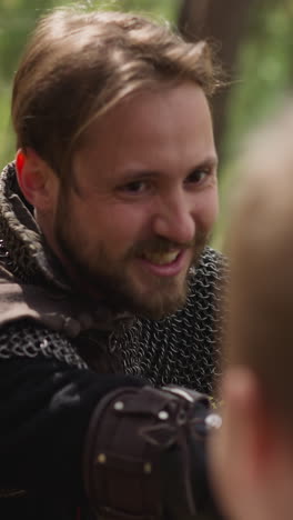 bearded man in knight armor fights with boy on swords at camp for medieval soldiers slow motion. attack and defense tricks. historical reconstruction