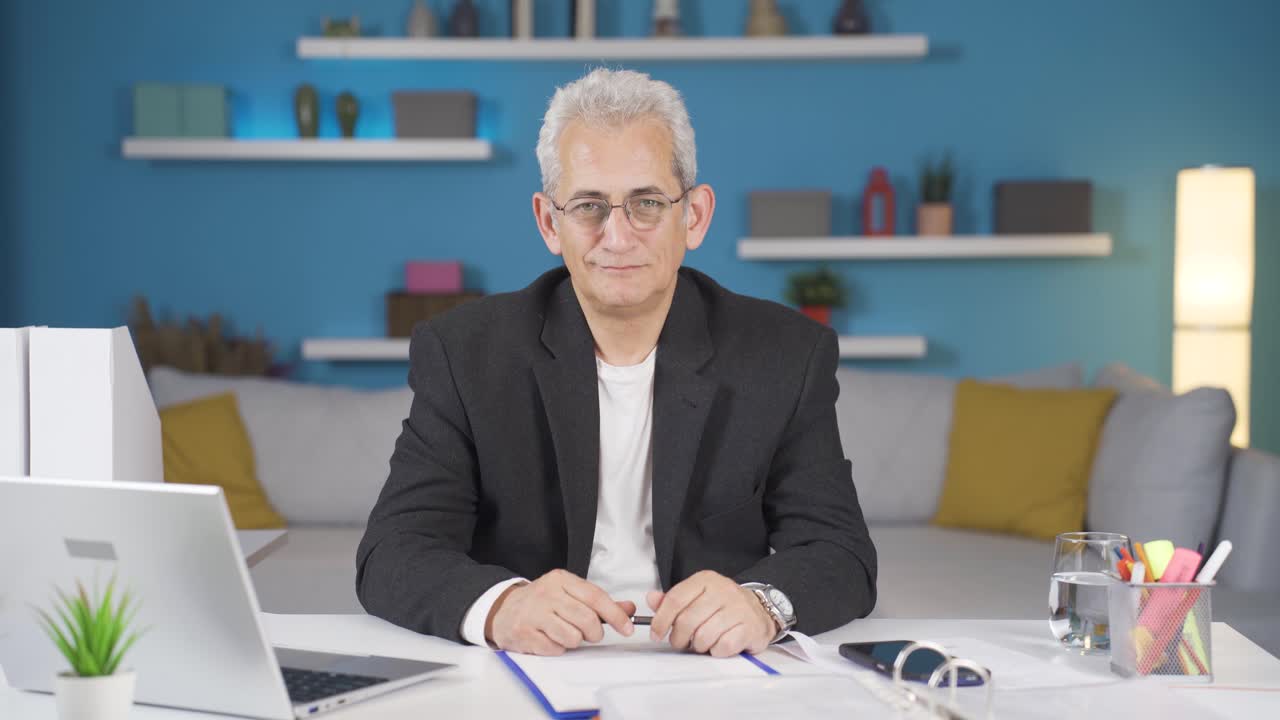 el hombre de la oficina en casa asiente a la cámara.