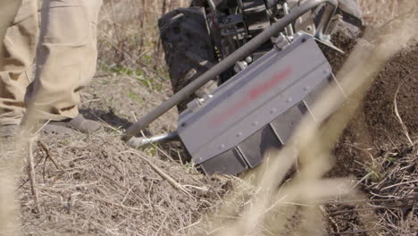 Rototiller-Arroja-Tierra-Vegetal,-Agricultura-En-Suecia,-Cámara-Lenta-De-Cerca