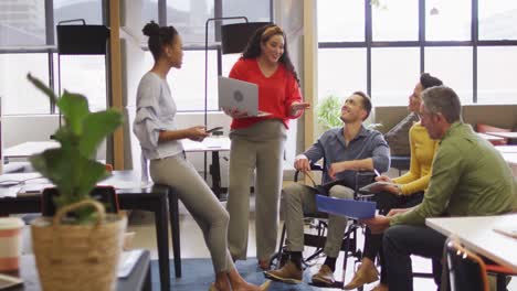 Happy-disabled-and-diverse-business-people-discussing-work-during-meeting-at-office