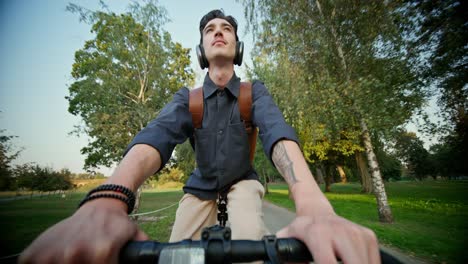 hombre en bicicleta en un parque con auriculares
