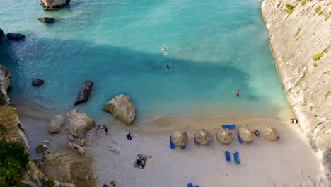 Toma-Aérea-De-La-Playa-De-Xigia-Con-Aguas-Turquesas,-Turistas-Y-Costa-Arenosa,-Zakynthos,-Grecia