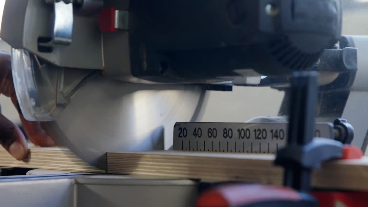 плотник режет деревянную доску электрической пилой в мастерской 4k