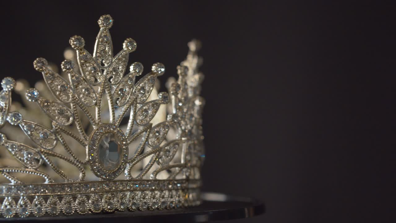 Beauty pageant, bride's or queen's crown on a turning display as in a museum, illuminated with black background