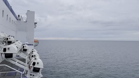 Side-of-a-white-car-ferry-in-autopa-on-the-sea-with-rescue-pods-attached-to-the-side