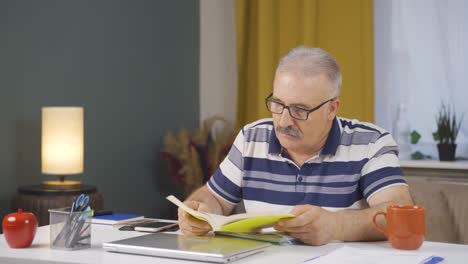 home office worker old man reading a book.