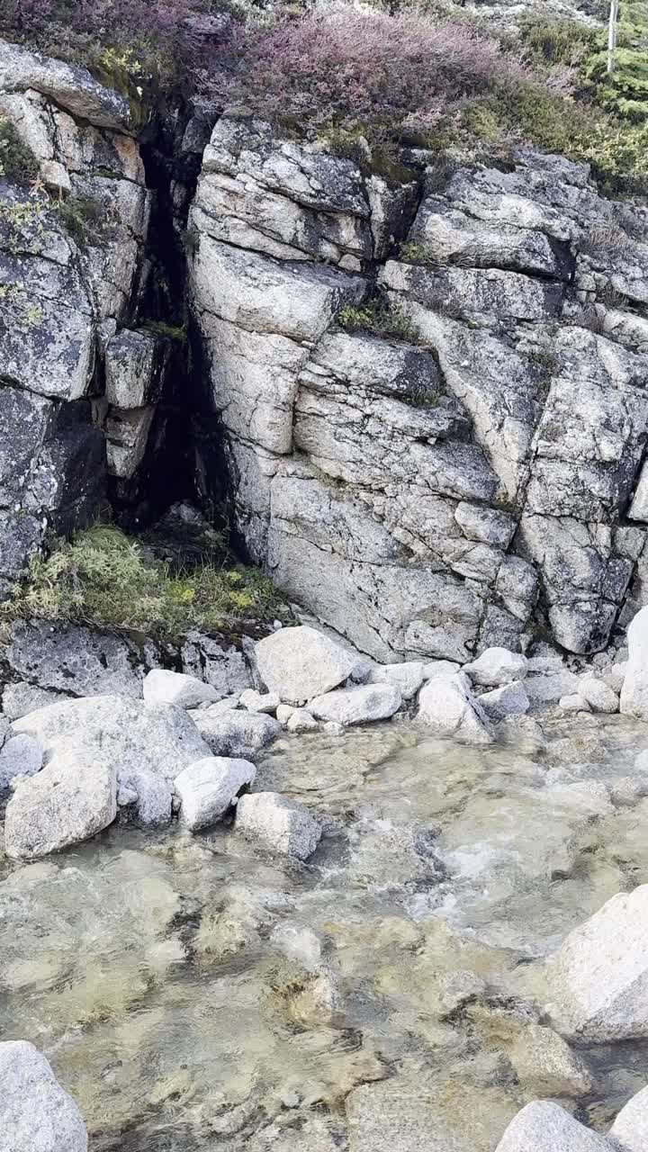 Tranquil waterfall cascades down a rugged mountain cliff