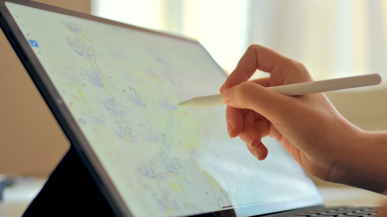 Woman drawing flowers on a tablet with a stylus pen