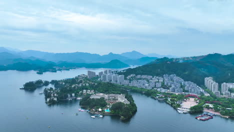 real estate concept, residential houses and apartment in a suburb near river with lots of trees between houses, with the lake and skyscrapers landmark building in the background, on a sunny day clouds