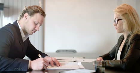 young businesspeople signing documents