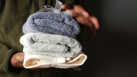 person holding a stack of folded towels