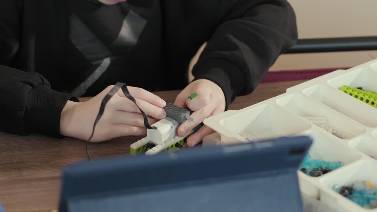 los niños participan en actividades de aprendizaje básico, montando kits de robótica con enfoque y trabajo en equipo en un entorno de aula