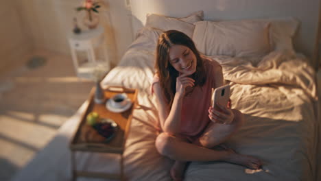 joyful woman videocalling online at home bedroom. smiling teenager waving mobile