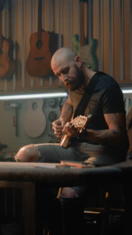 man playing guitar in a workshop