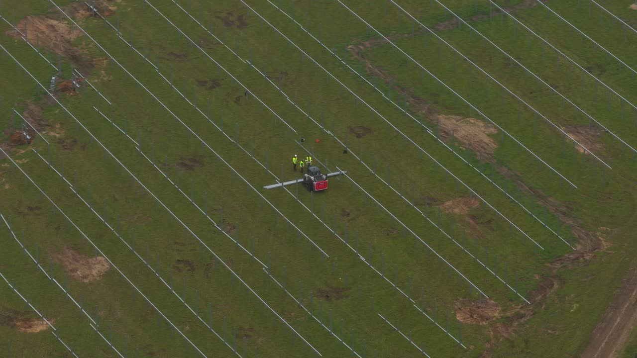 Workers and machinery building solar energy site in rural Germany
