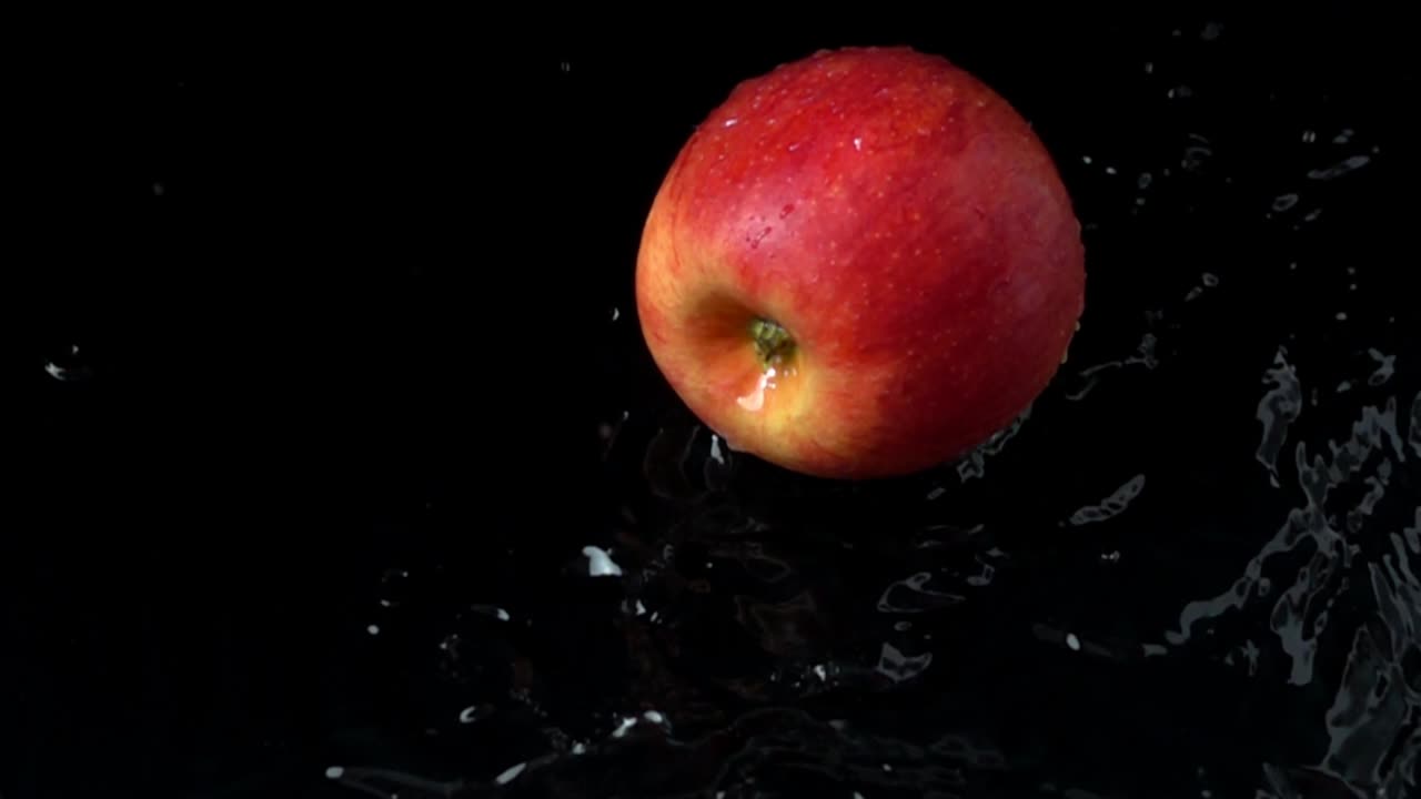 Æble falder i vand. Slowmotion