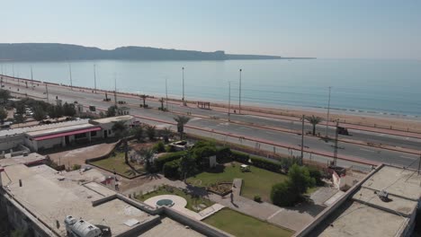 aerial shot of car running in the street of gawadar balochistan near the beach
