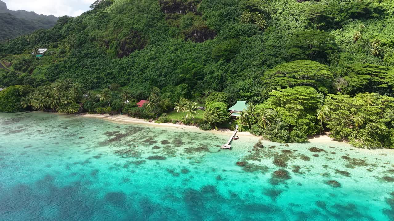 Huahine Island, French Polynesia. Drone Shot of Beach and Waterfront Hones Under Green Hills and Rainforest