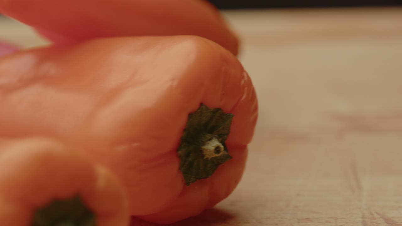 Fast dolly past multiple paprika's on a wooden cutting board