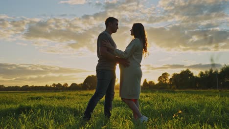 pregnant couple at sunset