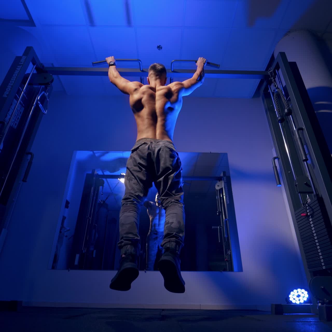Bodybuilder pulling up on horizontal bar