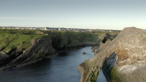 Eine-Luftaufnahme-Von-Bow-Fiddle-Rock-Bei-Portknockie-An-Einem-Ruhigen-Sommermorgen