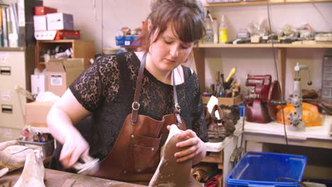 bespoke shoemaker pinning leather together to make shoe