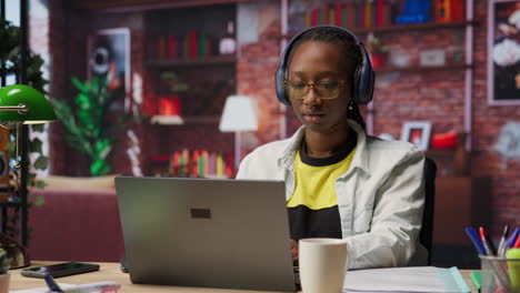 teleworker listening music while typing on notebook keyboard