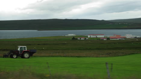 car driving past open landscape in iceland
