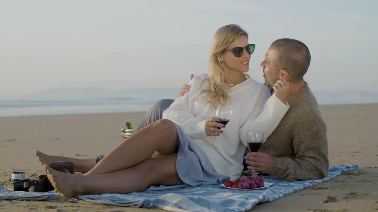 una pareja caucásica romántica haciendo picnic en la playa.