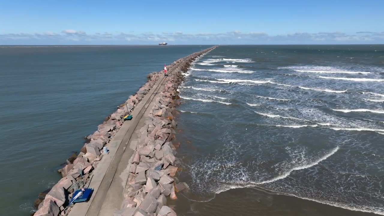 Vista estática del rompeolas que comienza en Molhes da Barra y se extiende hacia el océano en Rio Grande, Brasil.