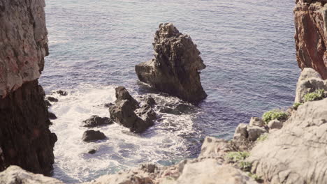 a giant rock with crystal clear water moving around in portugal