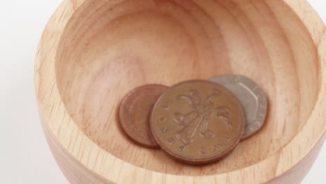 uk currency pounds sterling coins falling and spinning in slow motion close up rotating footage against the white background