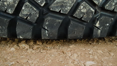 a dolly macro shot of a tire laying on gravel on the ground