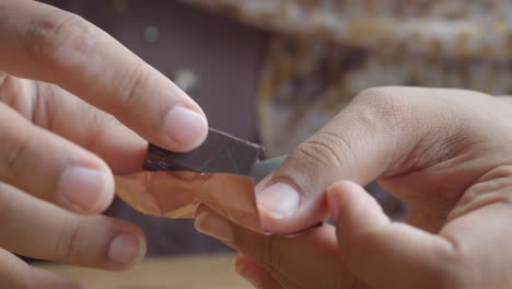 close-up of hands unwrapping a piece of chocolate