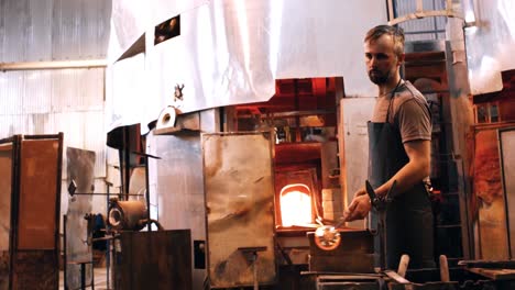 glassblower shaping a molten glass