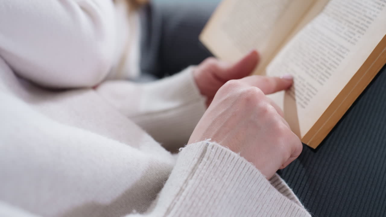 Close up of female hand pointing finger at line while reading book, focusing on text with gesture emphasizing words, symbolizing study, storytelling, education, knowledge sharing, learning