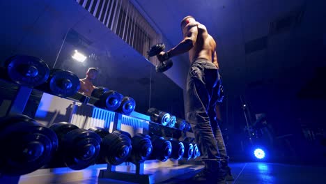 fitness man with dumbbell in gym. muscular bodybuilder guy doing exercises with dumbbells