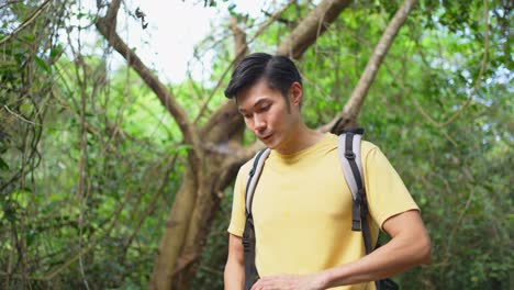 man hiking and drinking water in the forest