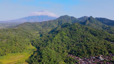 vista aérea del paisaje rural indonesio, tierras de cultivo, bosques y colinas con cielo azul