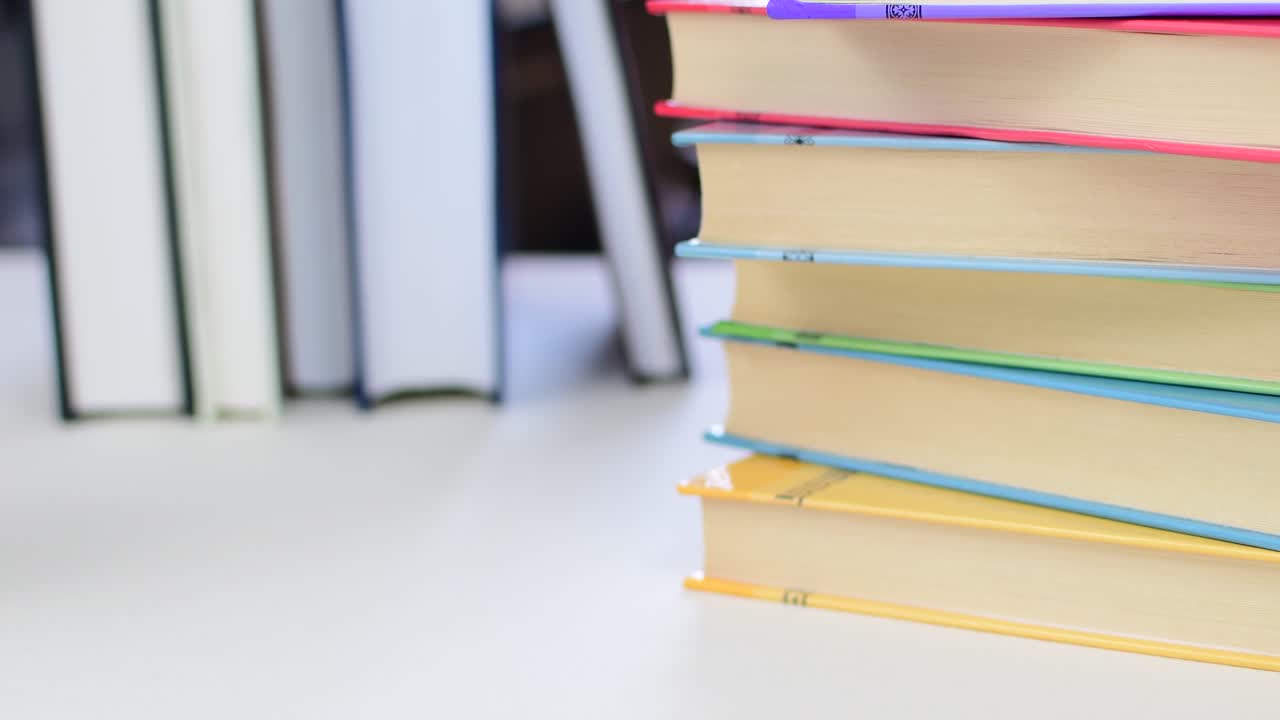 Desk with stack of study books. Textbooks for the student, university. Study from home. Distance education concept.