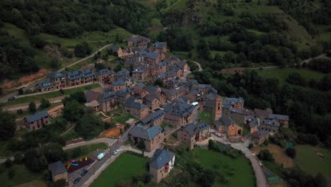 Imágenes-Aéreas-Horizontales-De-4k-De-Un-Pequeño-Pueblo-Español-Con-Casas-En-Un-Entorno-Natural-Verde-En-Los-Pirineos-Españoles