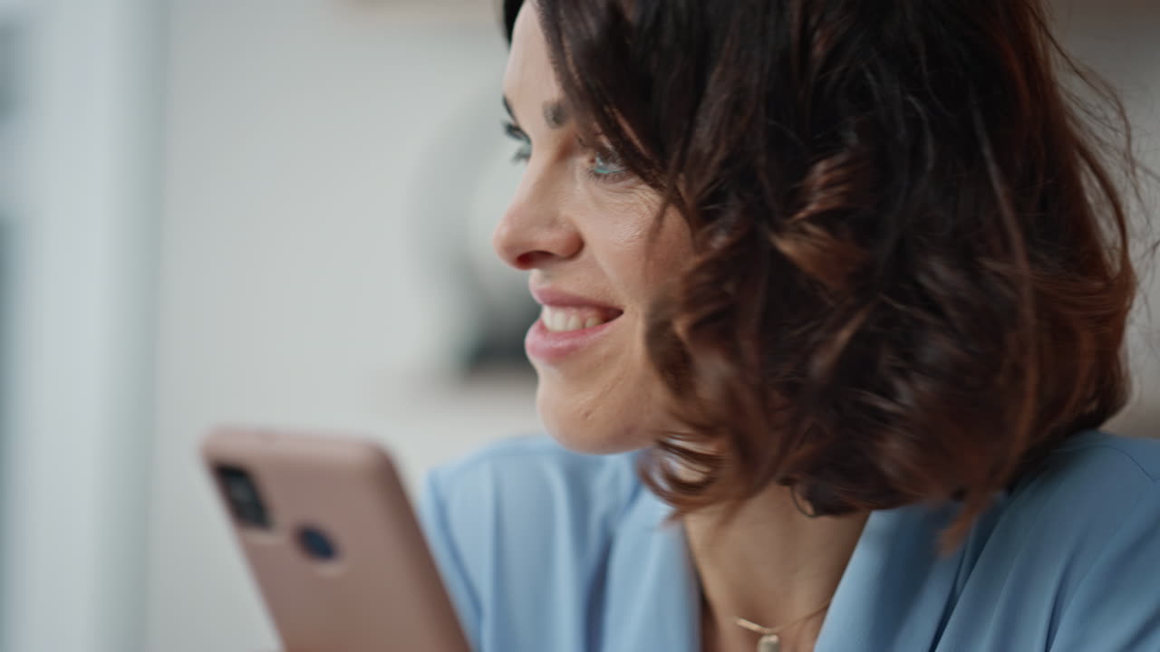 Relaxed woman messaging smartphone in remote office closeup. Smiling manager