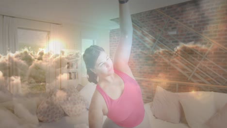 animation of sunset with clouds over woman exercising and stretching at home