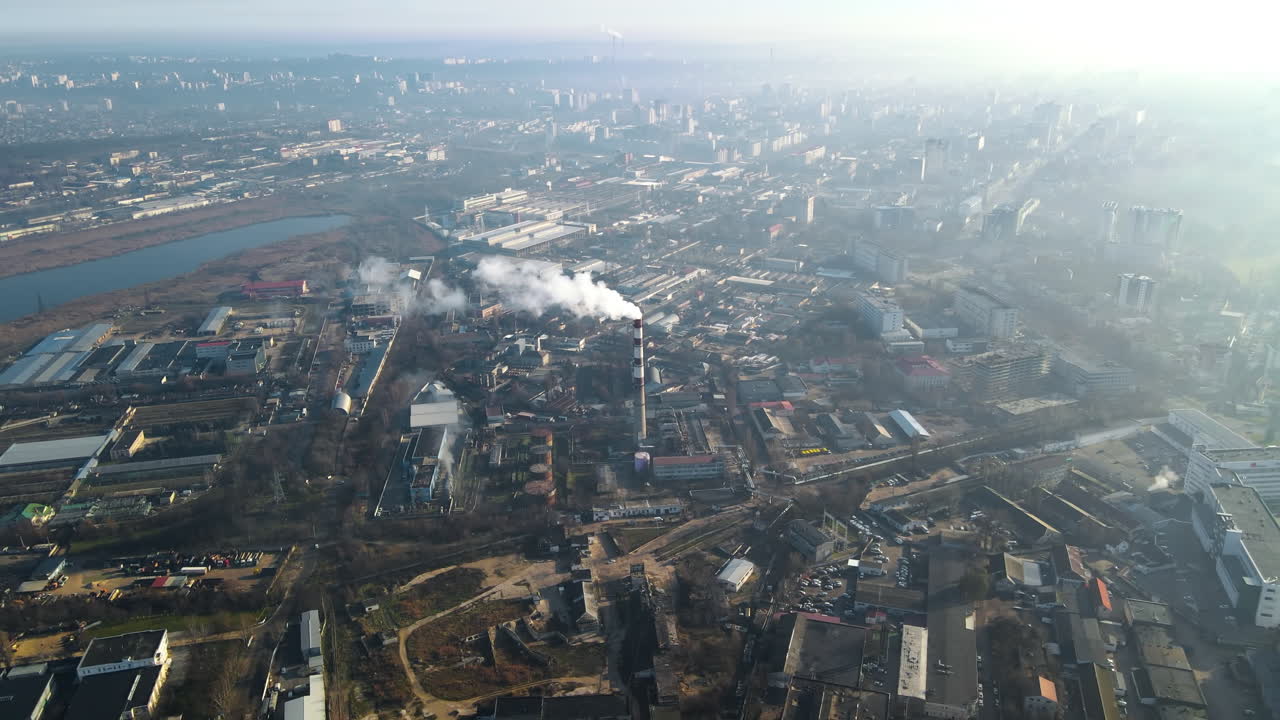 Vista aérea con dron de Chisinau. Central térmica con humo saliendo de la chimenea. Edificios, carreteras, lago. Niebla en el aire. Moldavia