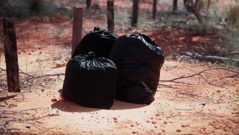 Primer-Plano-De-Bolsas-De-Basura-Llenas-En-La-Arena