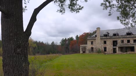 panning shot of an abandoned and spooky old boarding school or mansion in the countryside