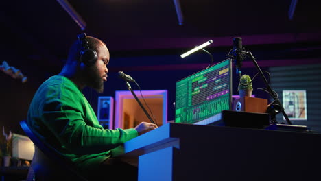 african american music producer twisting knobs on mixing console